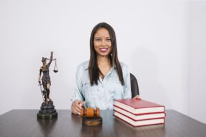 Lady sitting with some law books and a gavel on the table